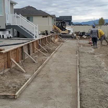 Concrete project in progress with forms set, base preparation underway, and the layout ready for a new pour.