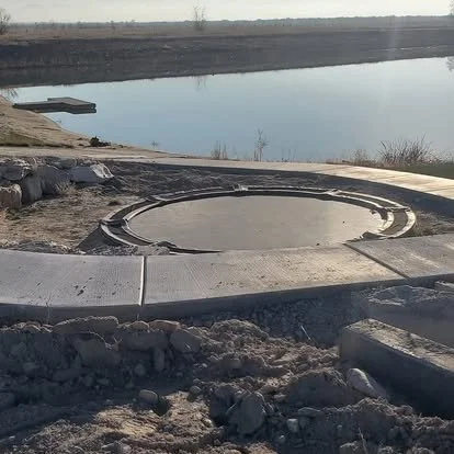 Circular concrete patio project near the water with forms and base preparation in place for a custom outdoor space.