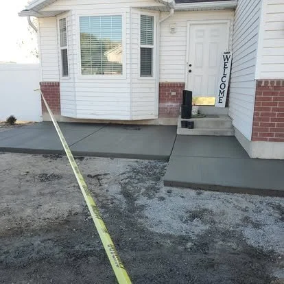 Finished front entry concrete walkway with a smooth surface, clean edges, and a simple residential layout.