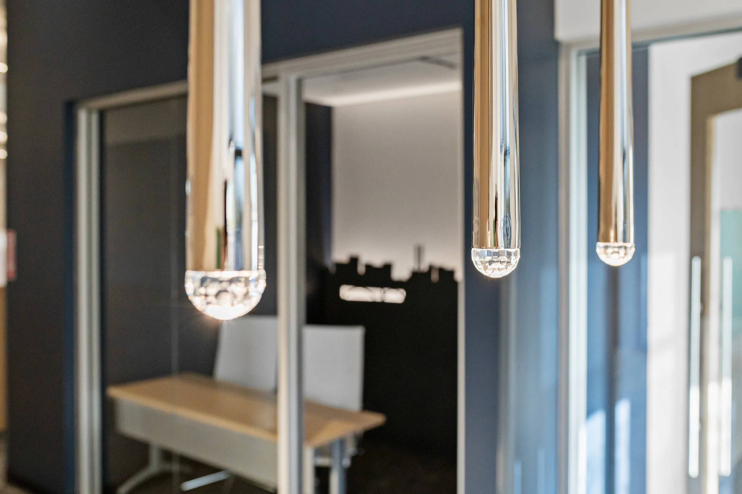 Close-up of modern pendant lights with clear glass or crystal finish hanging from the ceiling
