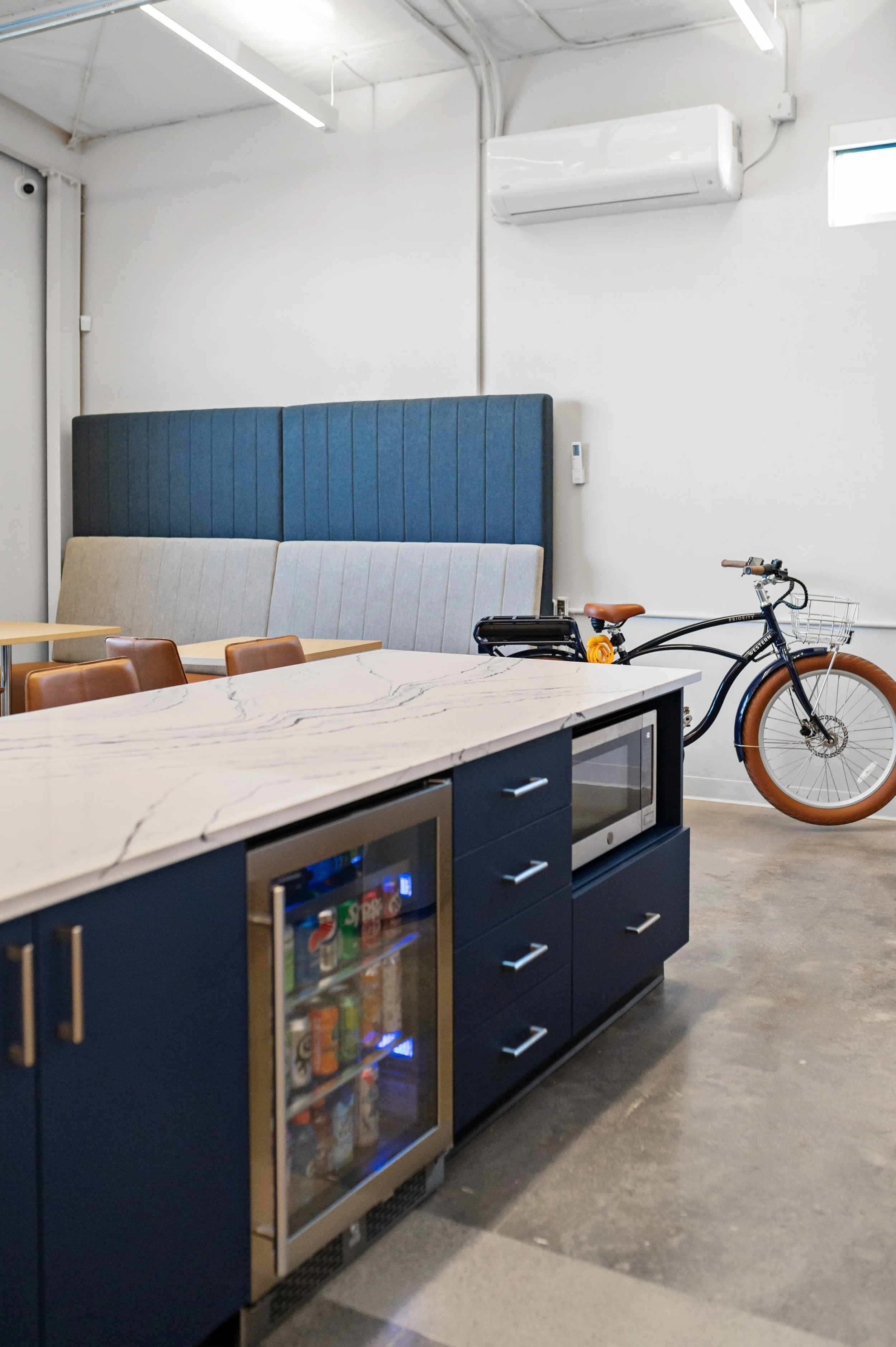 Western Insurance kitchen with marble countertop, dark blue cabinets, and a mini refrigerator