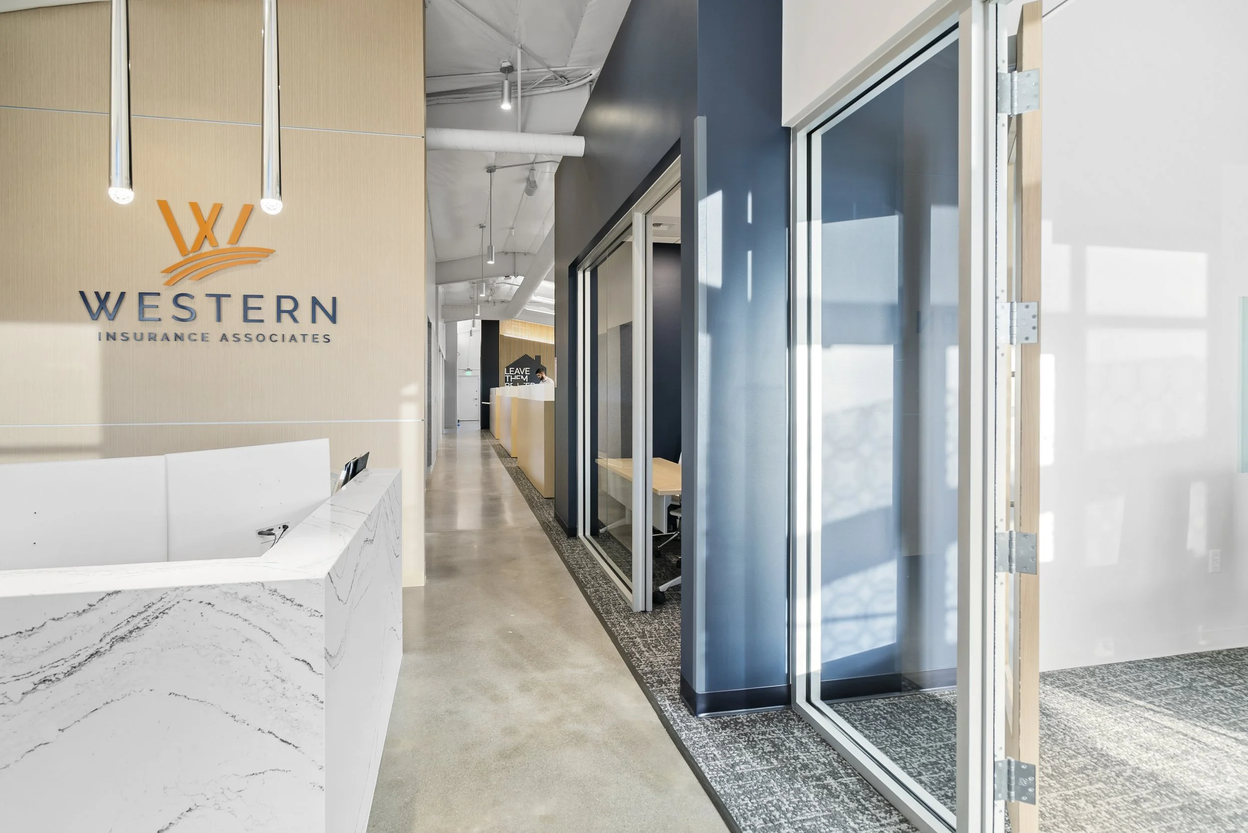 Western Insurance modern office lobby with a reception desk, logo wall for Western Insurance Associates