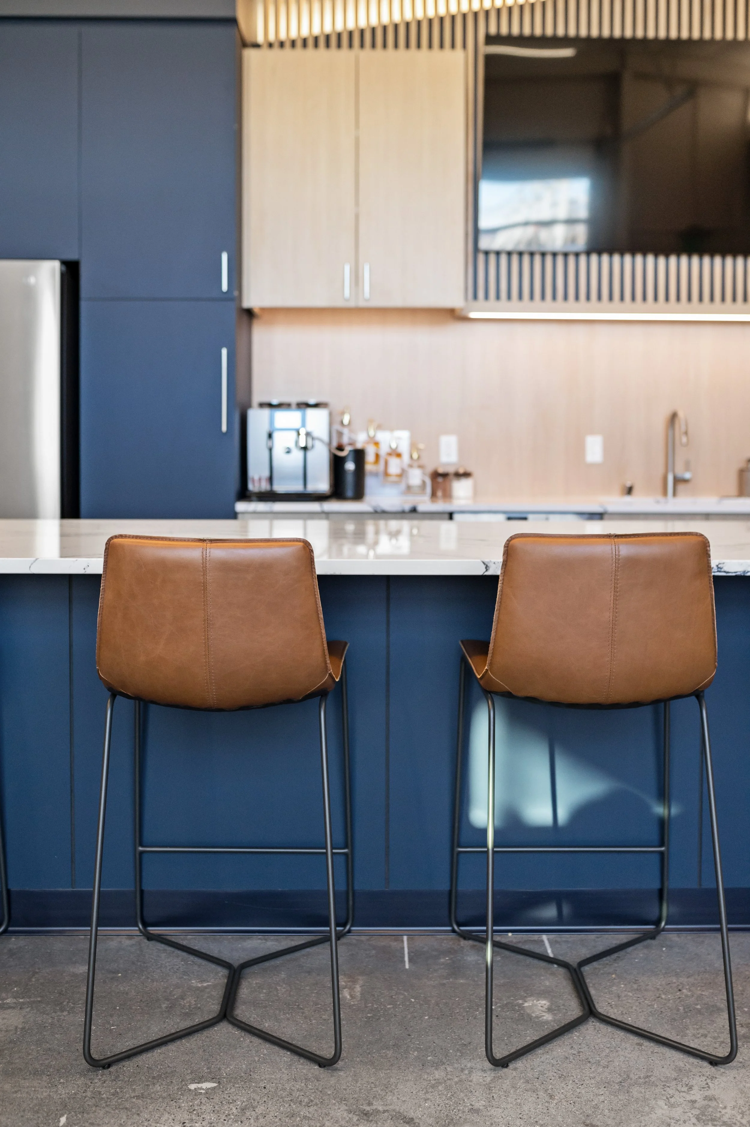 Western Insurance kitchen with leather bar stools and blue kitchen accents