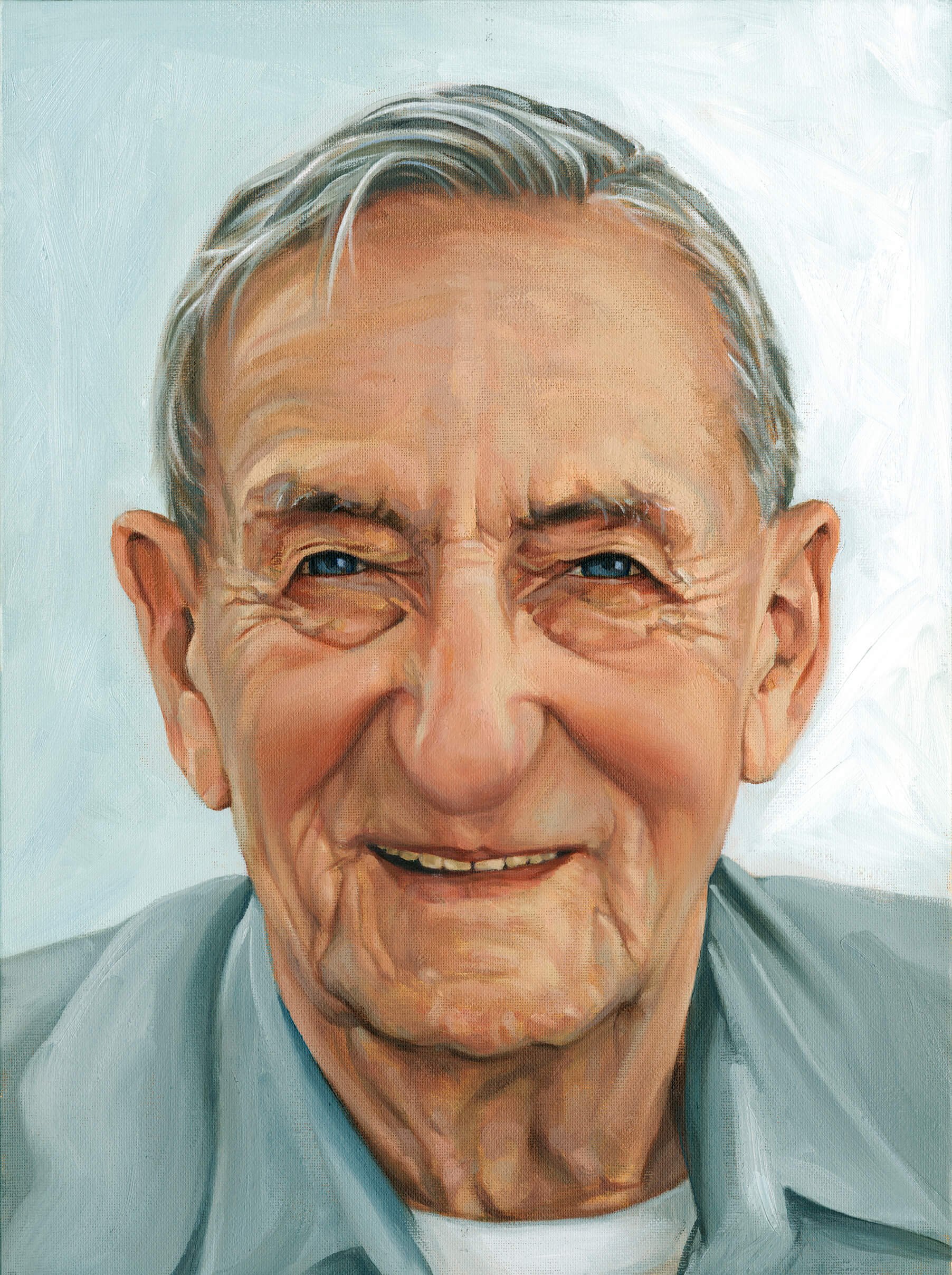 Close-up portrait of an elderly man with gray hair, smiling, wearing a bluish shirt.