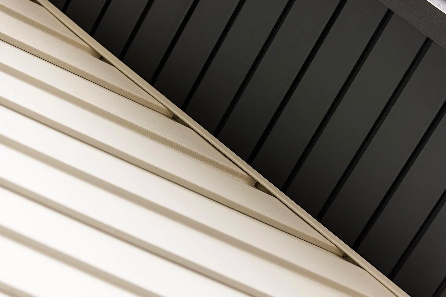 Close-up of three different textured panels, black, beige, and white, with the panels aligned diagonally.