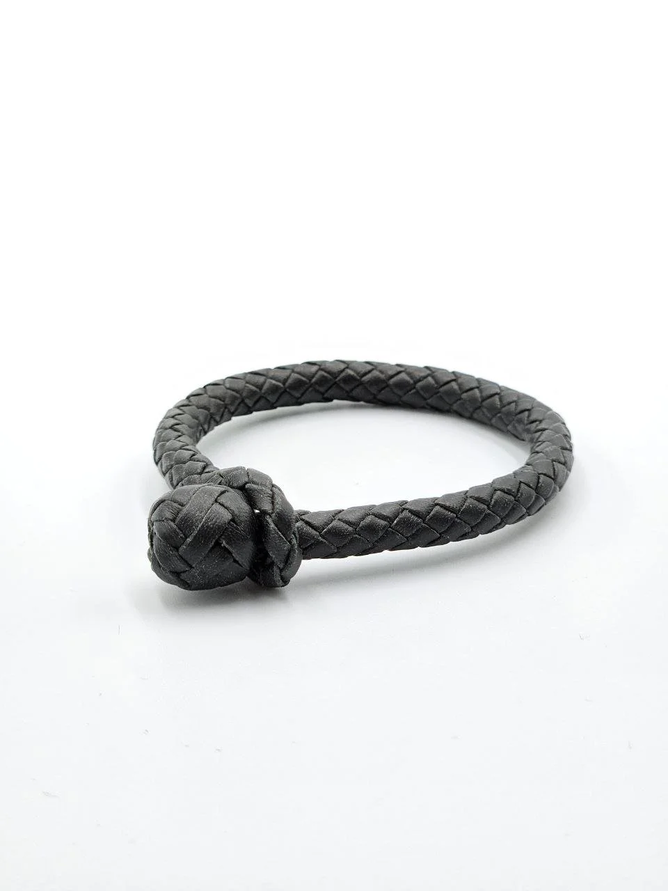 Black braided leather bracelet with a spherical knot closure on a white background.