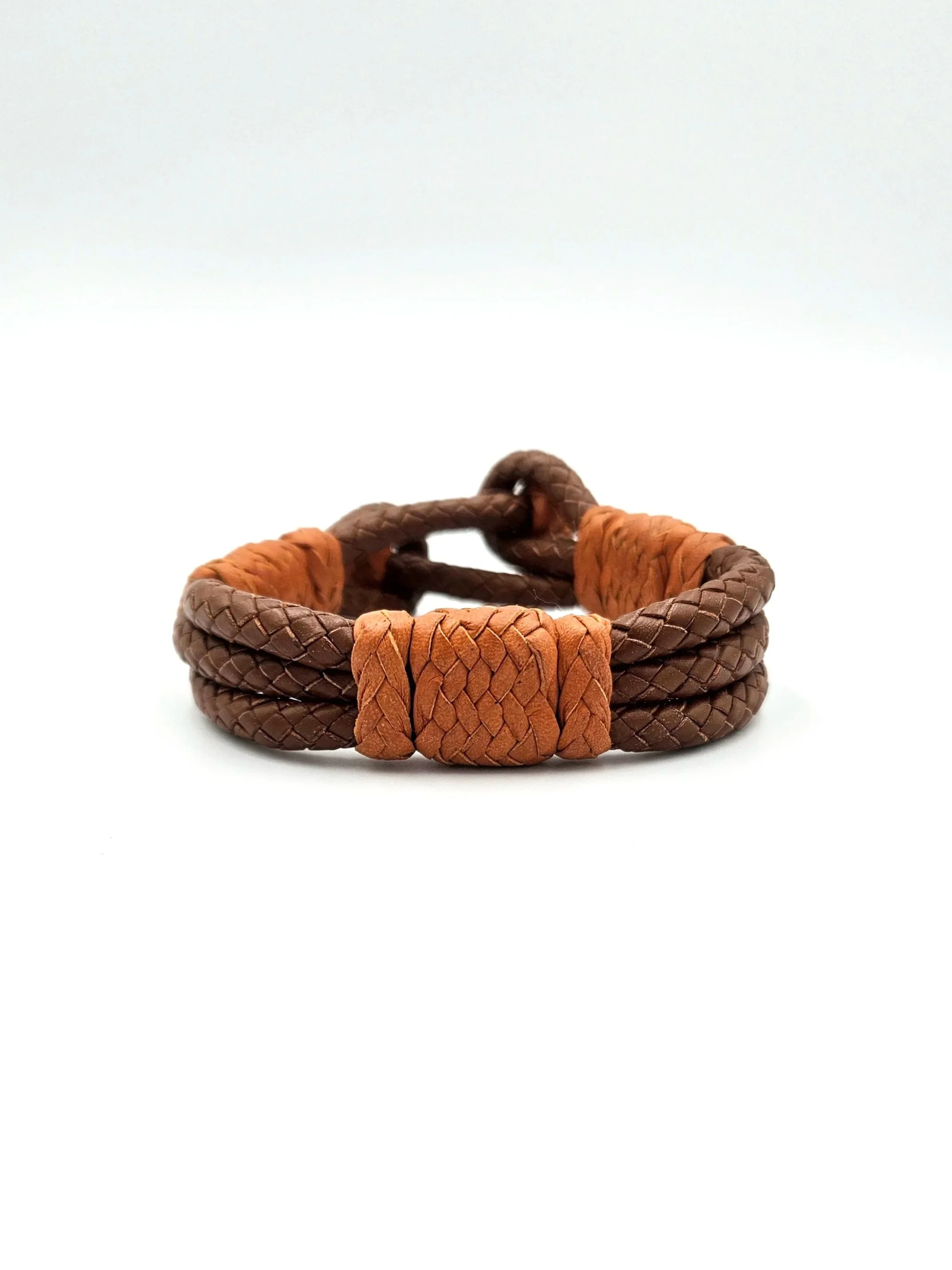 Close-up of a brown and orange braided leather bracelet on a white background.