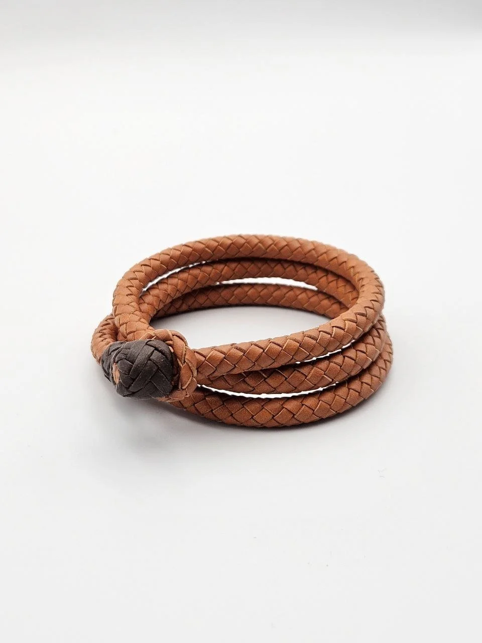 Brown braided leather bracelet with a dark brown knot on a white background
