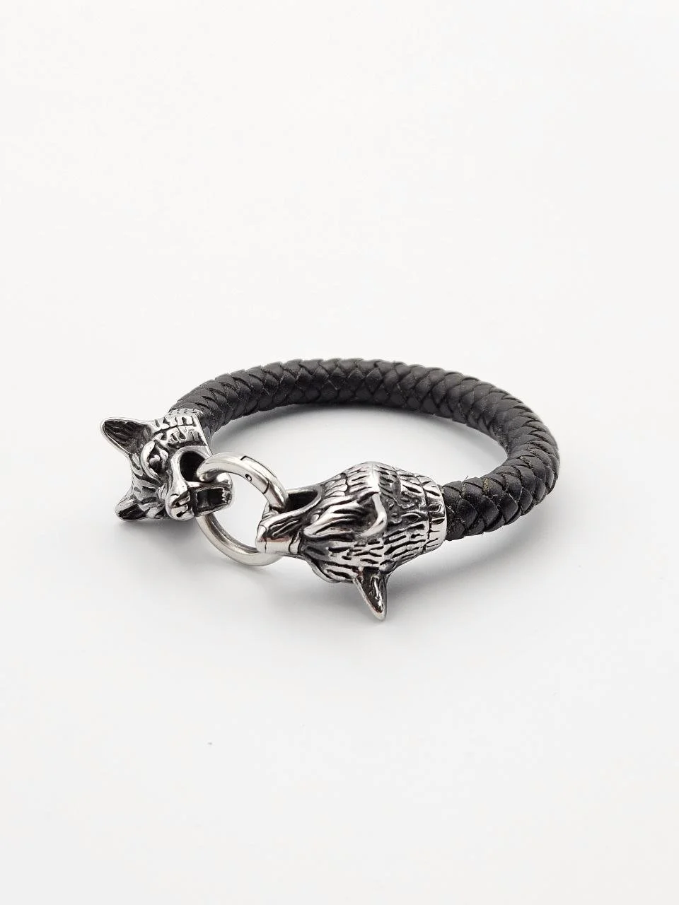 Black braided leather bracelet with silver wolf head and paw charms.