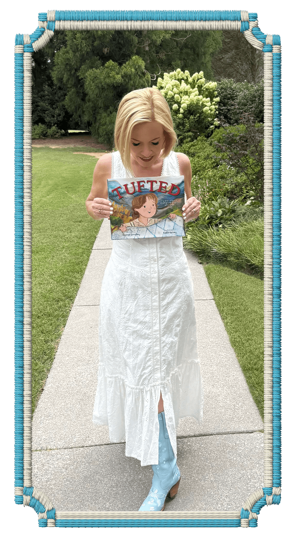 Rachel Smalley in a white dress and blue cowboy boots walking on a sidewalk while holding a children's book titled "TUFTED" in an outdoor garden setting.
