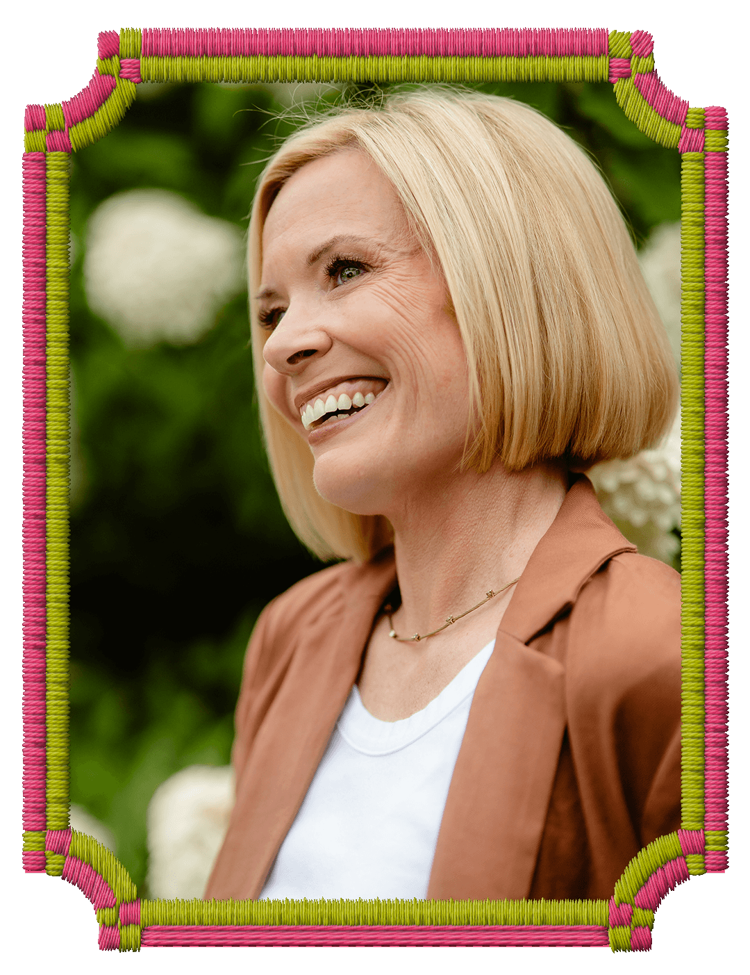 Rachel Smalley portrait, wearing a brown blazer and a white shirt, standing outdoors with a blurred green background.