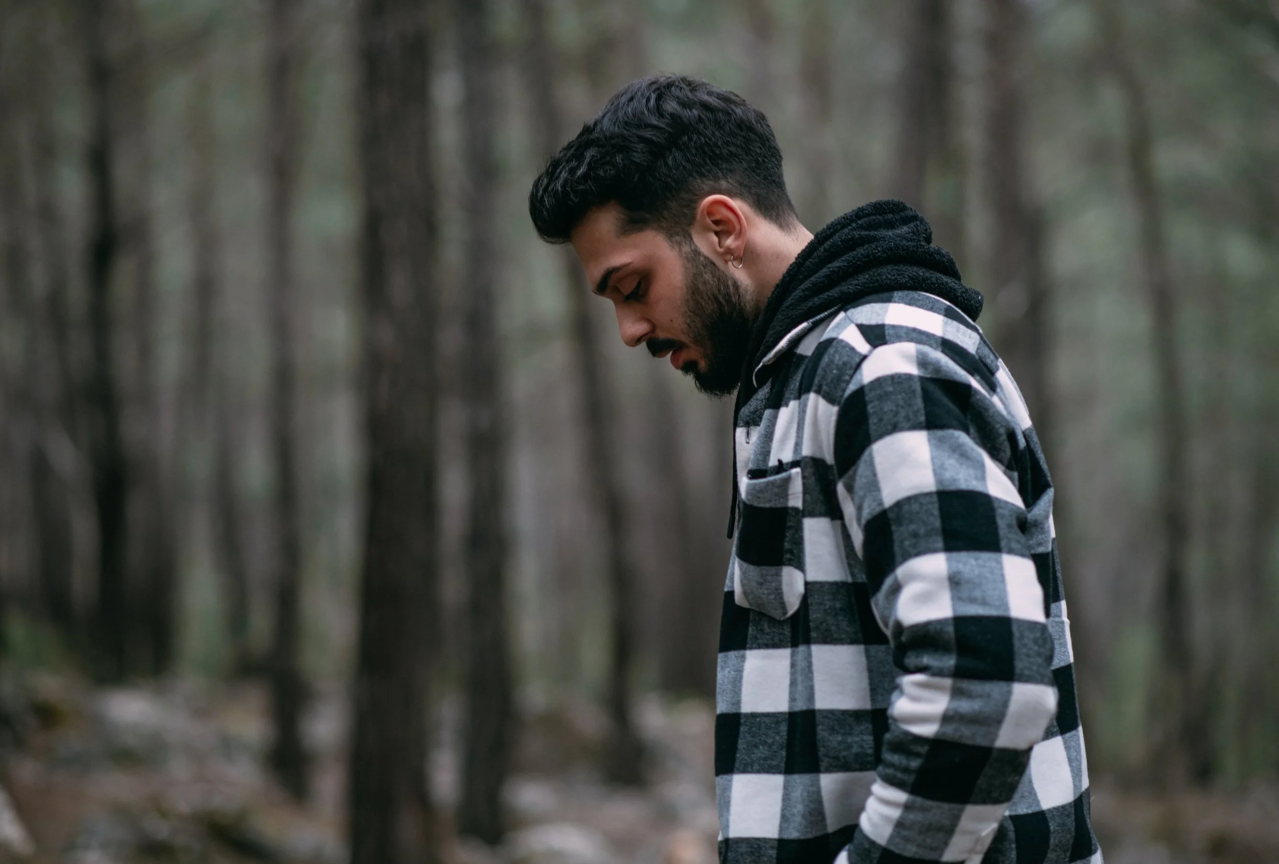 Man in quiet reflection in Pacific Northwest forest — adult therapy for trauma and anxiety at EMDR Resource Center Portland Oregon
