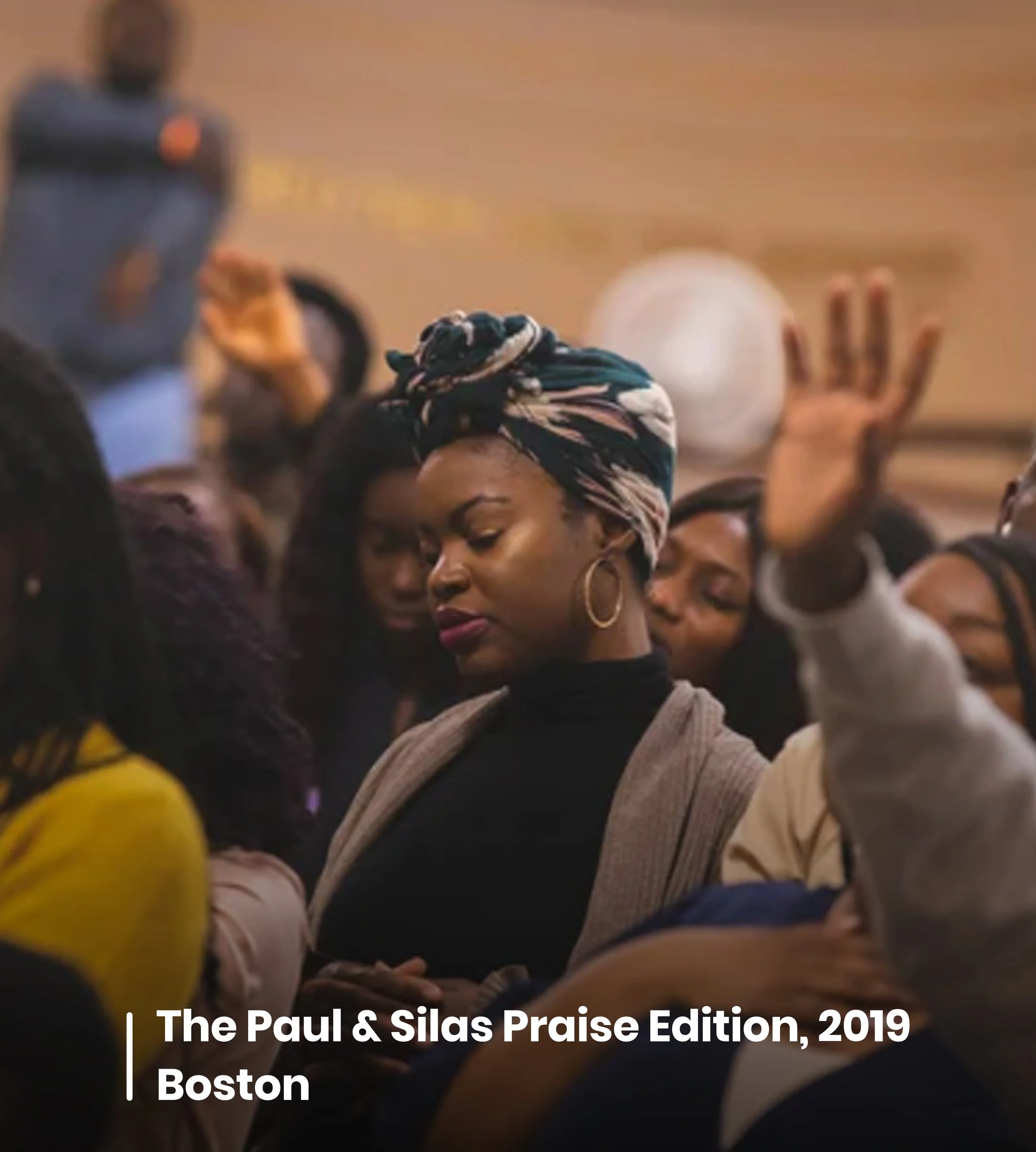 Group of people raising their hands in celebration or praise in an indoor setting, with the text "The Paul & Silas Praise Edition, 2019 Boston" overlaid at the bottom.