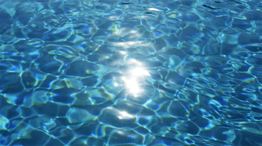 Sunlight reflecting on clear blue water surface.