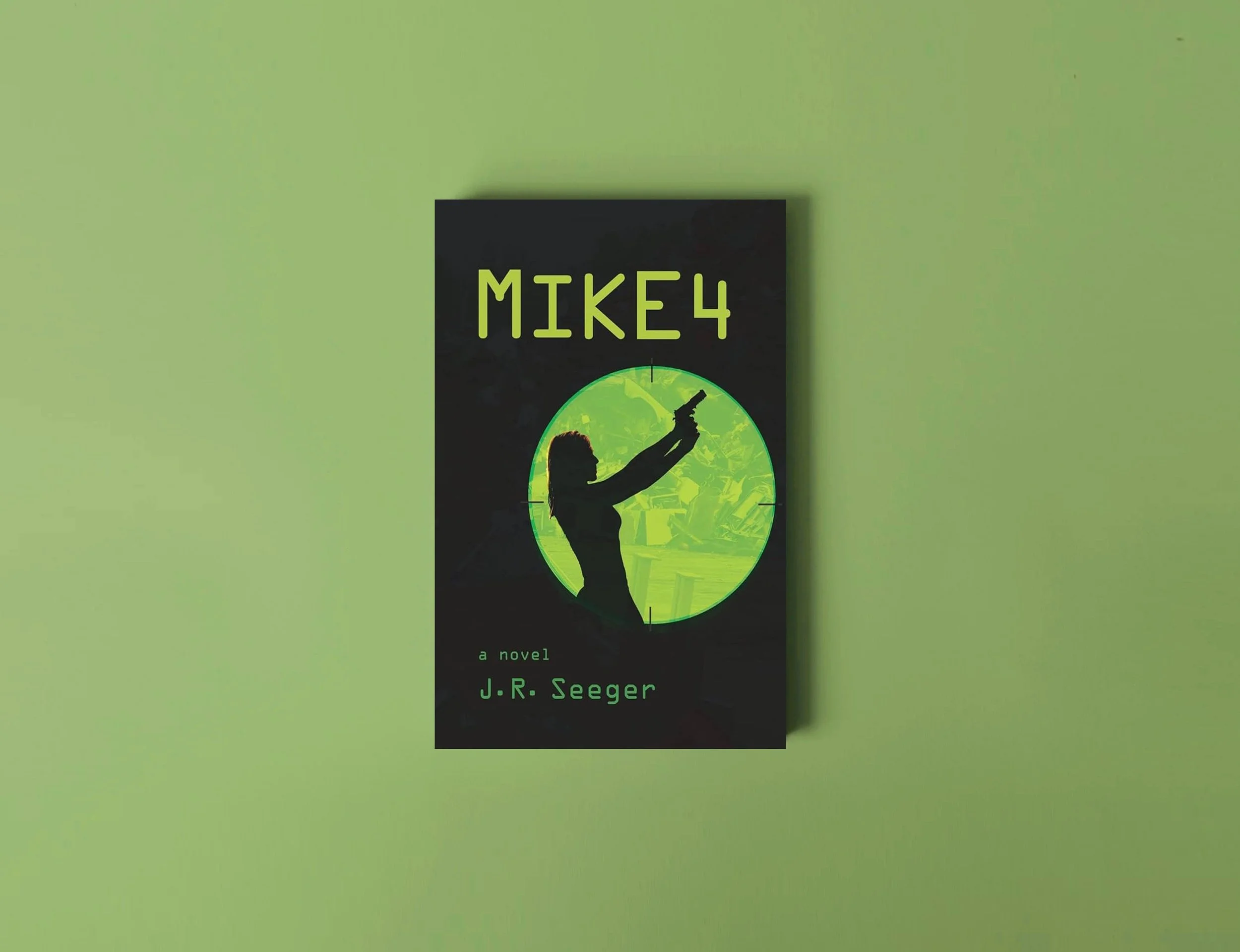 Book cover titled 'MIKE 4' by J.R. Seeger, featuring a silhouette of a woman pointing a gun with a greenish background.