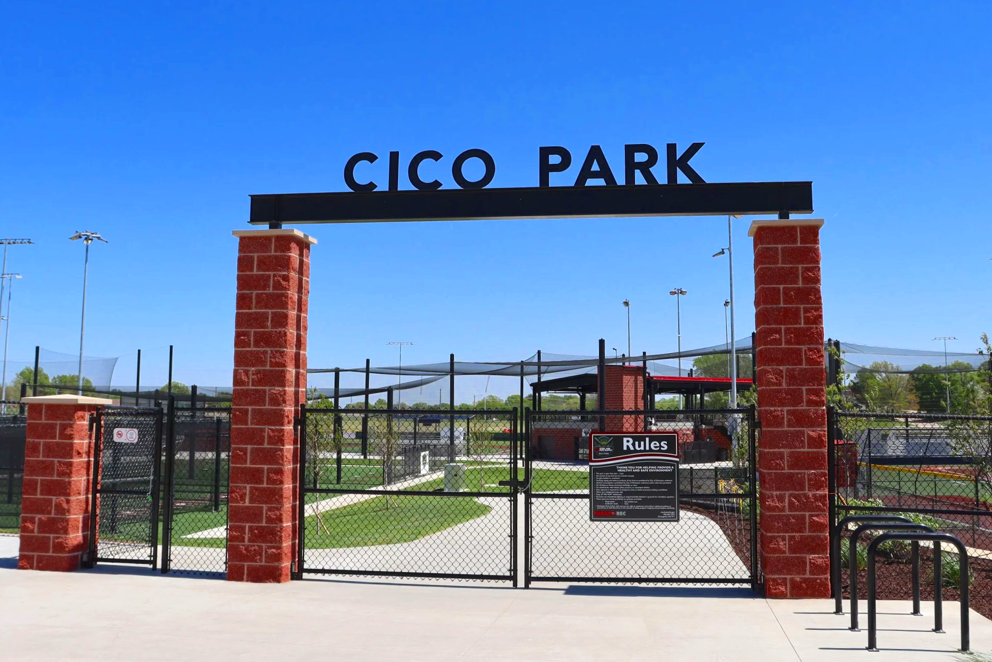Custom facility entrance signage at Cico Park athletic complex with baseball fields and netting