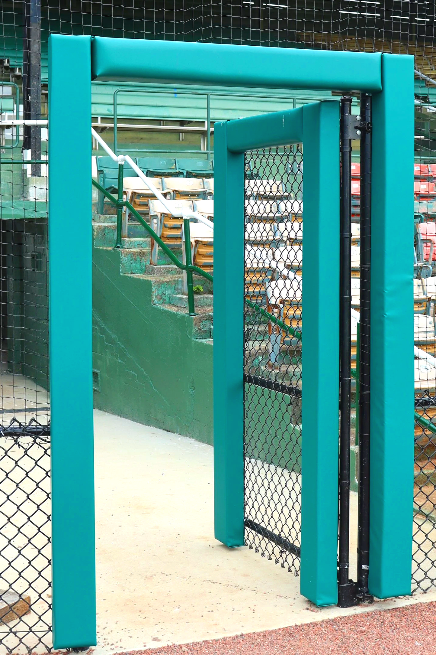 Teal post and column padding installed on dugout door frame and entry post at historic Rickwood Field in Birmingham Alabama — USS post and column padding supplier and sports field padding supplier protecting athletes from structural contact on door f