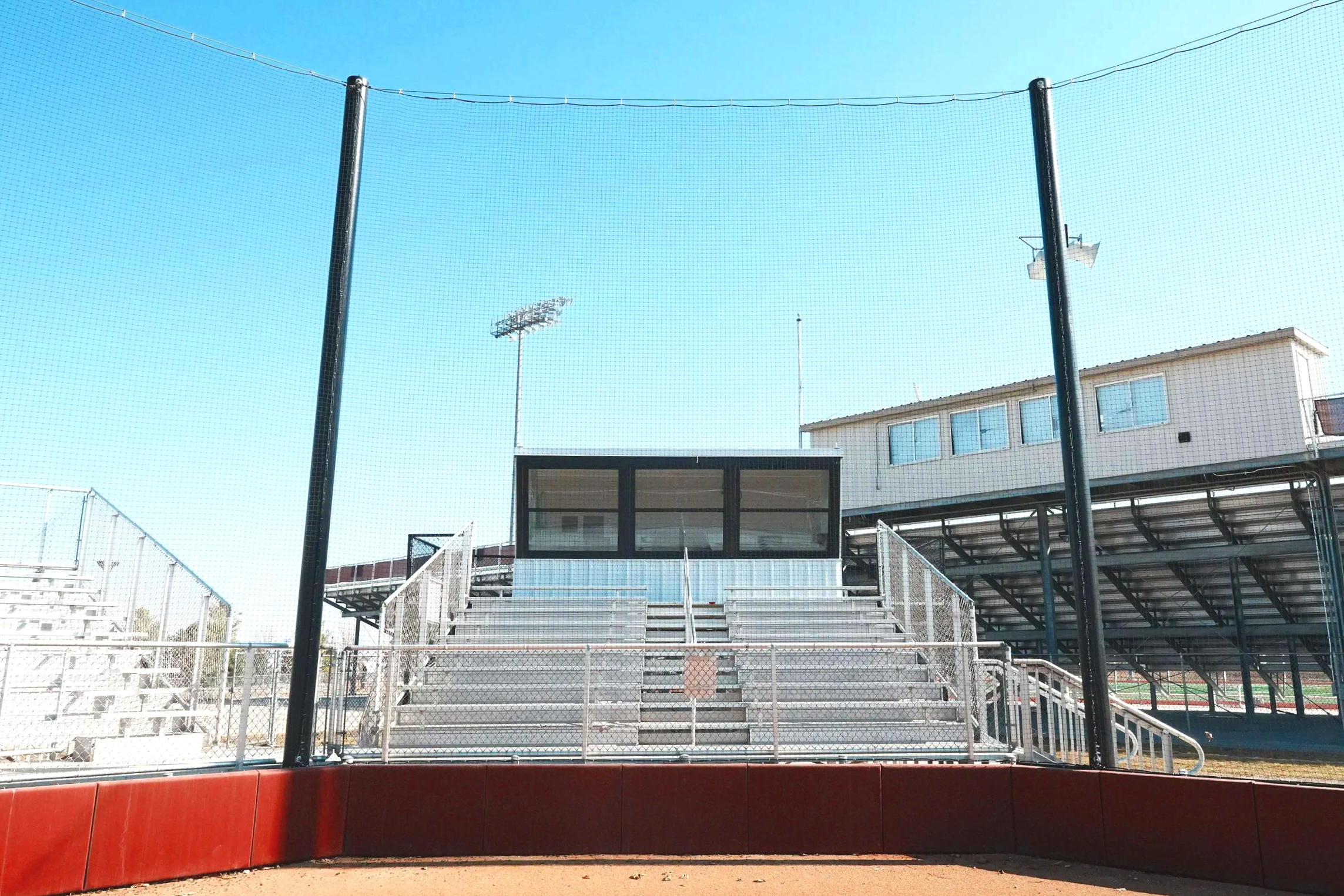 USS press box, aluminum bleachers, and barrier netting working together at Waverly High School in Waverly, Nebraska — a complete athletic facility installation from one supplier. Supplied by Unlimited Sports Solutions.