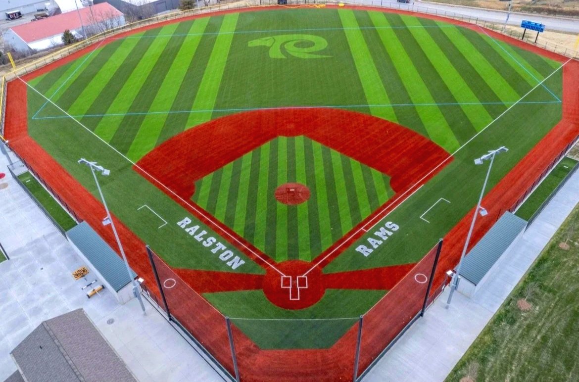 Aerial view of Ralston High School Rams baseball field with custom turf logo and red warning track in Ralston Nebraska