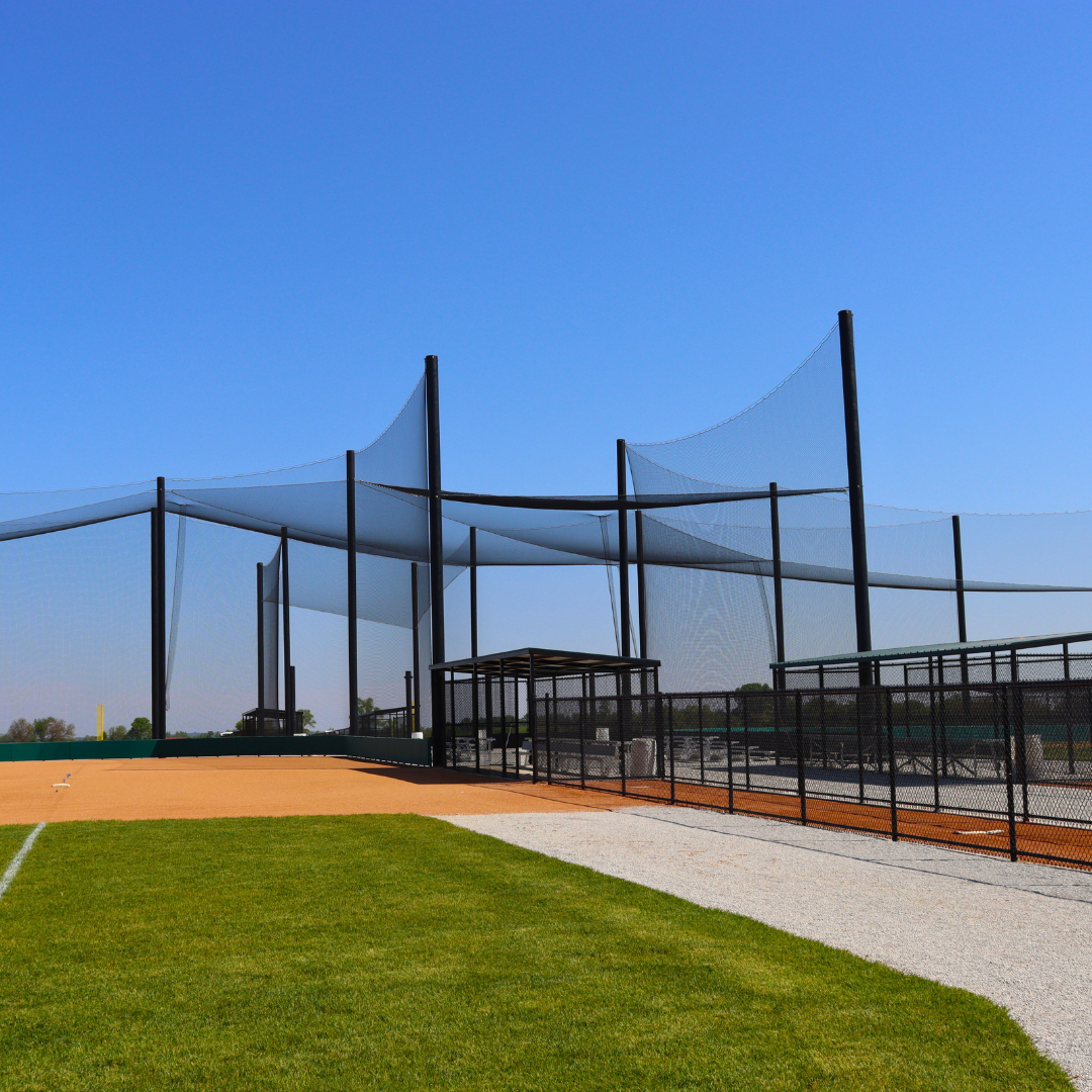 Baseball field protective netting system along outfield foul line at athletic facility