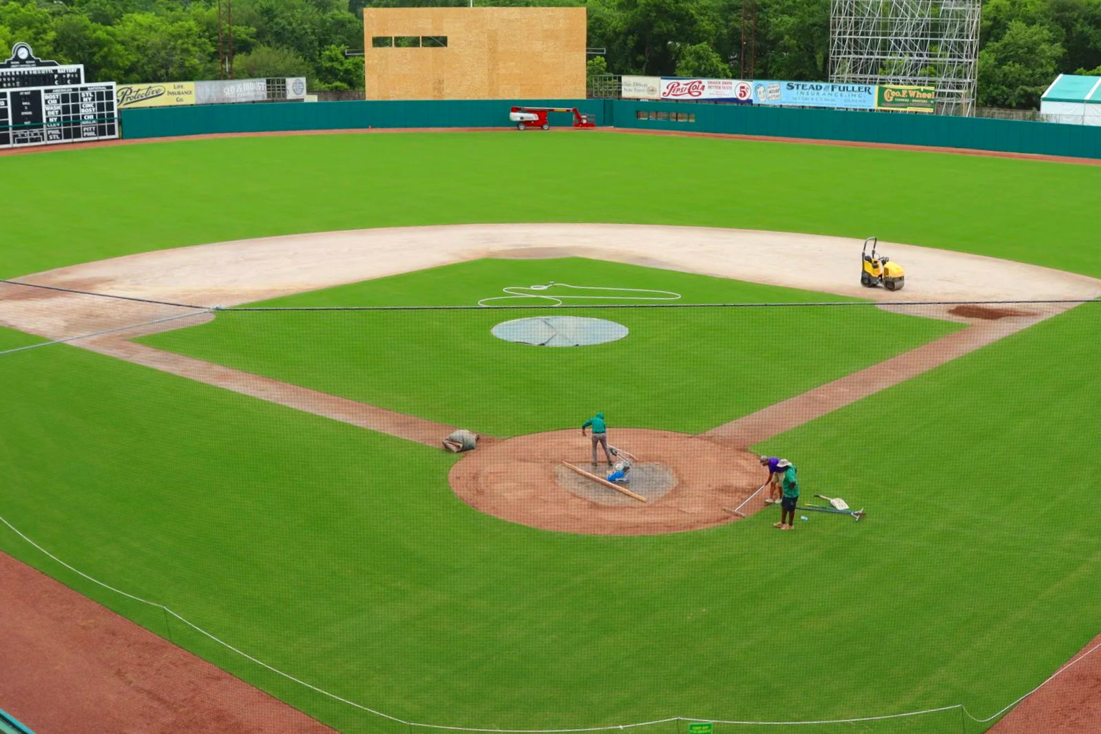 t: Groundskeepers maintaining infield at historic Rickwood Field baseball stadium