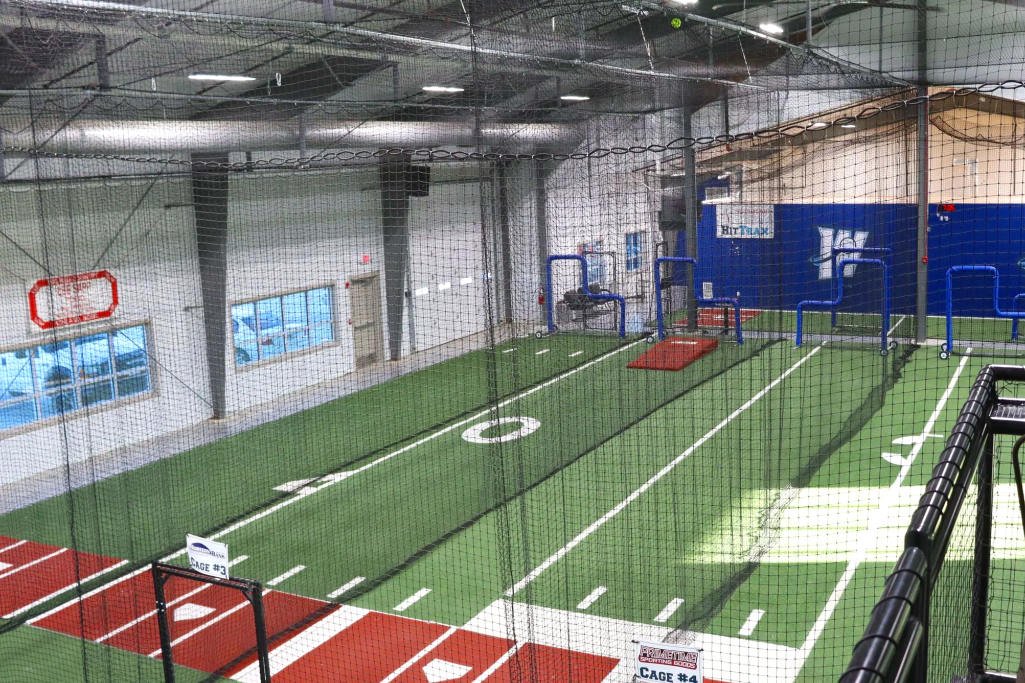 Portable pitching mounds and platforms in indoor baseball training facility with batting cage netting and HitTrax technology — USS portable pitching mound supplier for indoor athletic training facilities