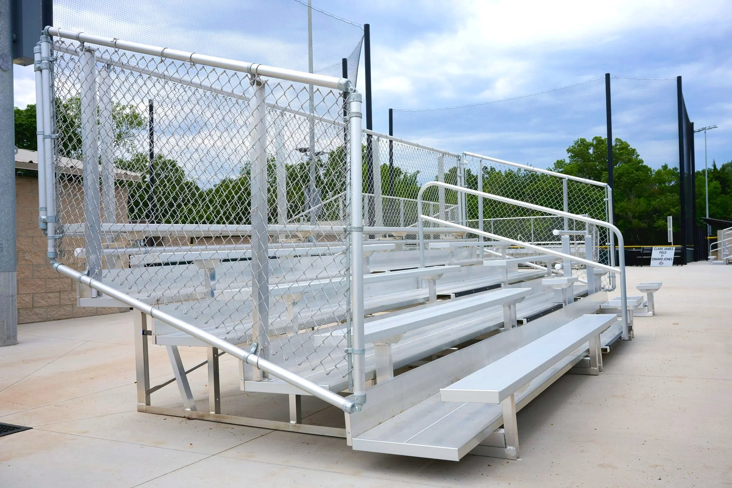 Aluminum bleachers at baseball facility with chain link fence and backstop netting