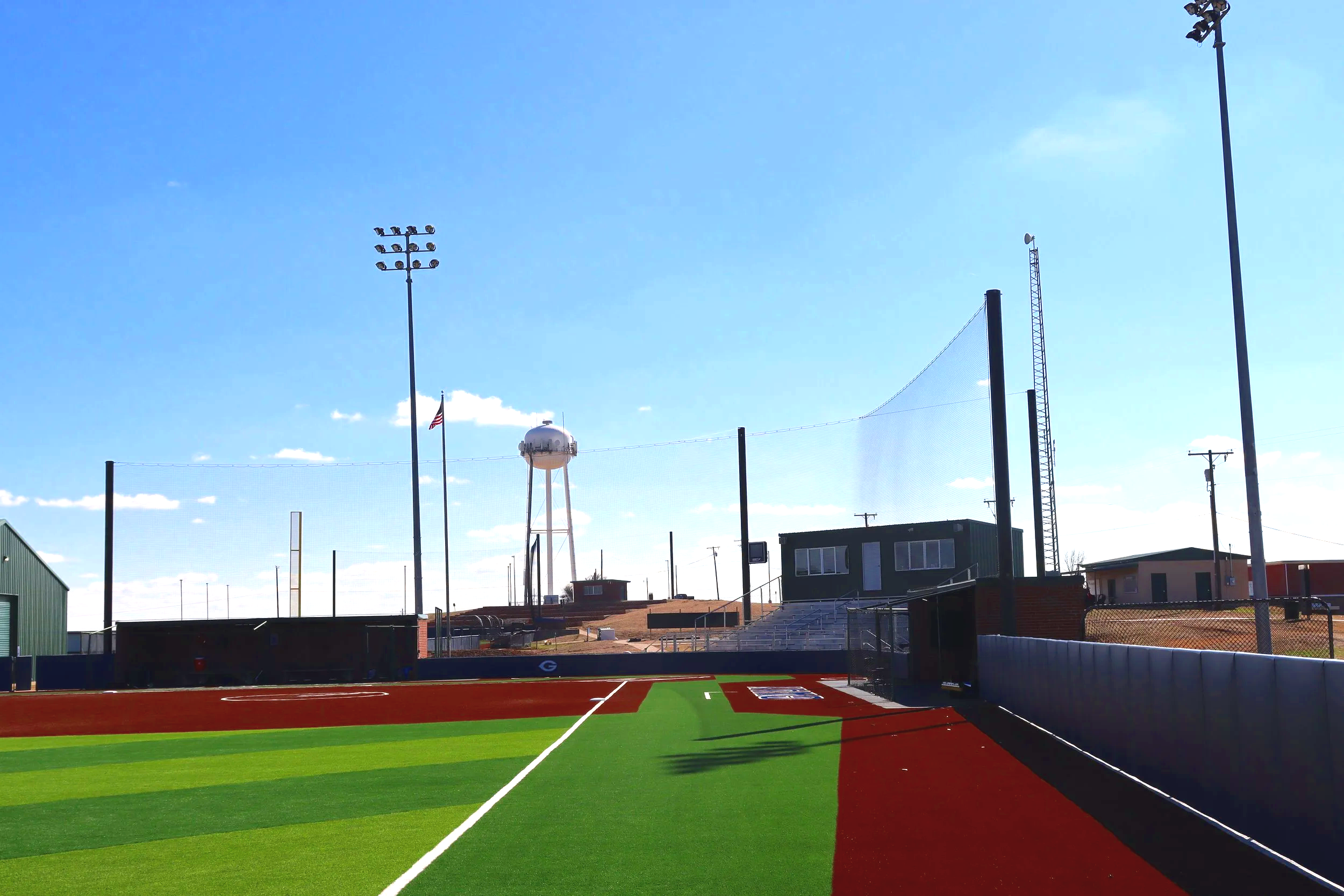 High school athletic baseball field with artificial turf and outfield netting at Grayson College Denison Texas