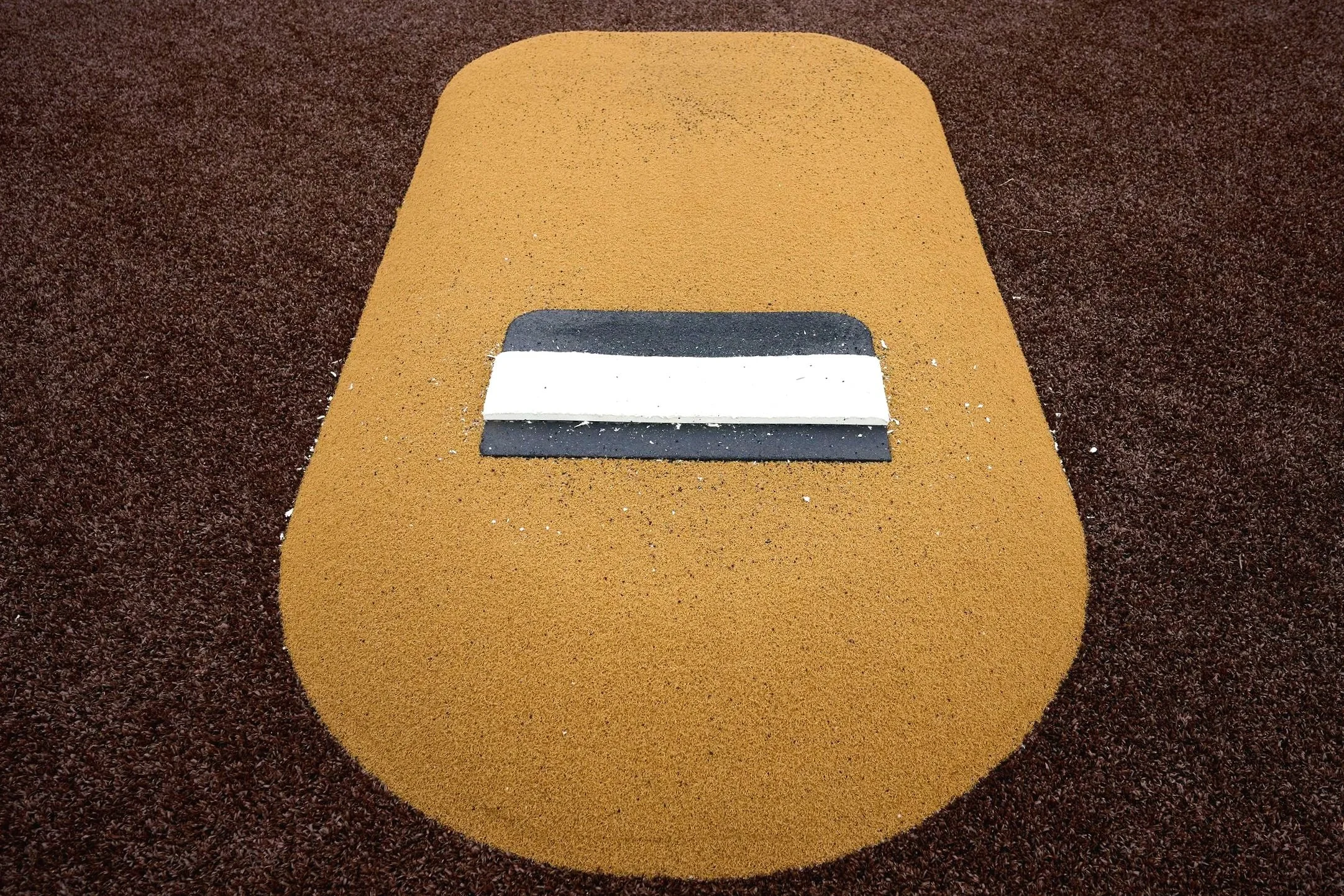 Portolite portable pitching mound close-up on natural dirt baseball field — USS Portolite pitching mound dealer and portable pitching mound supplier