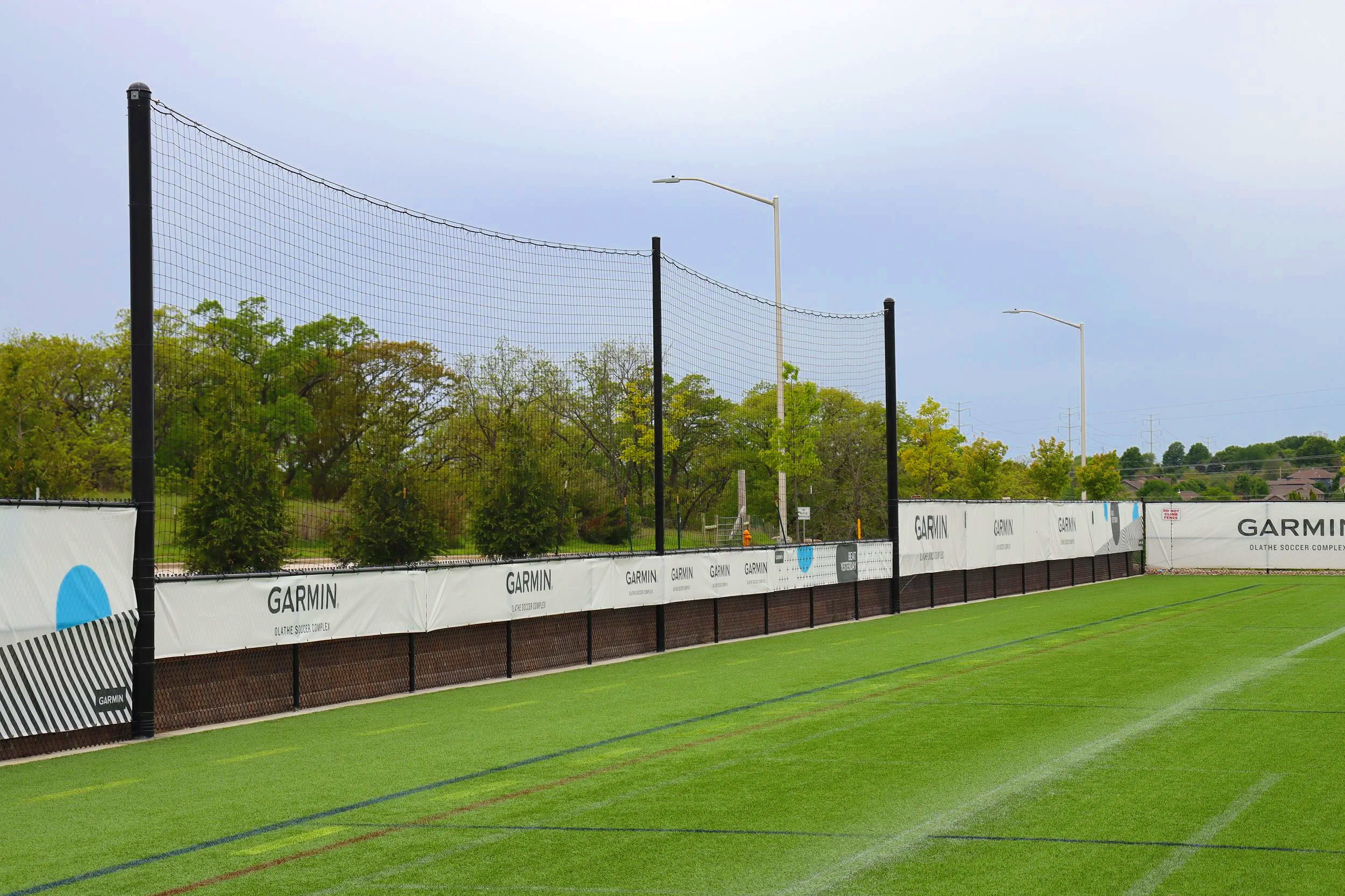 Garmin sponsored windscreen branding on outfield fence at municipal parks athletic facility