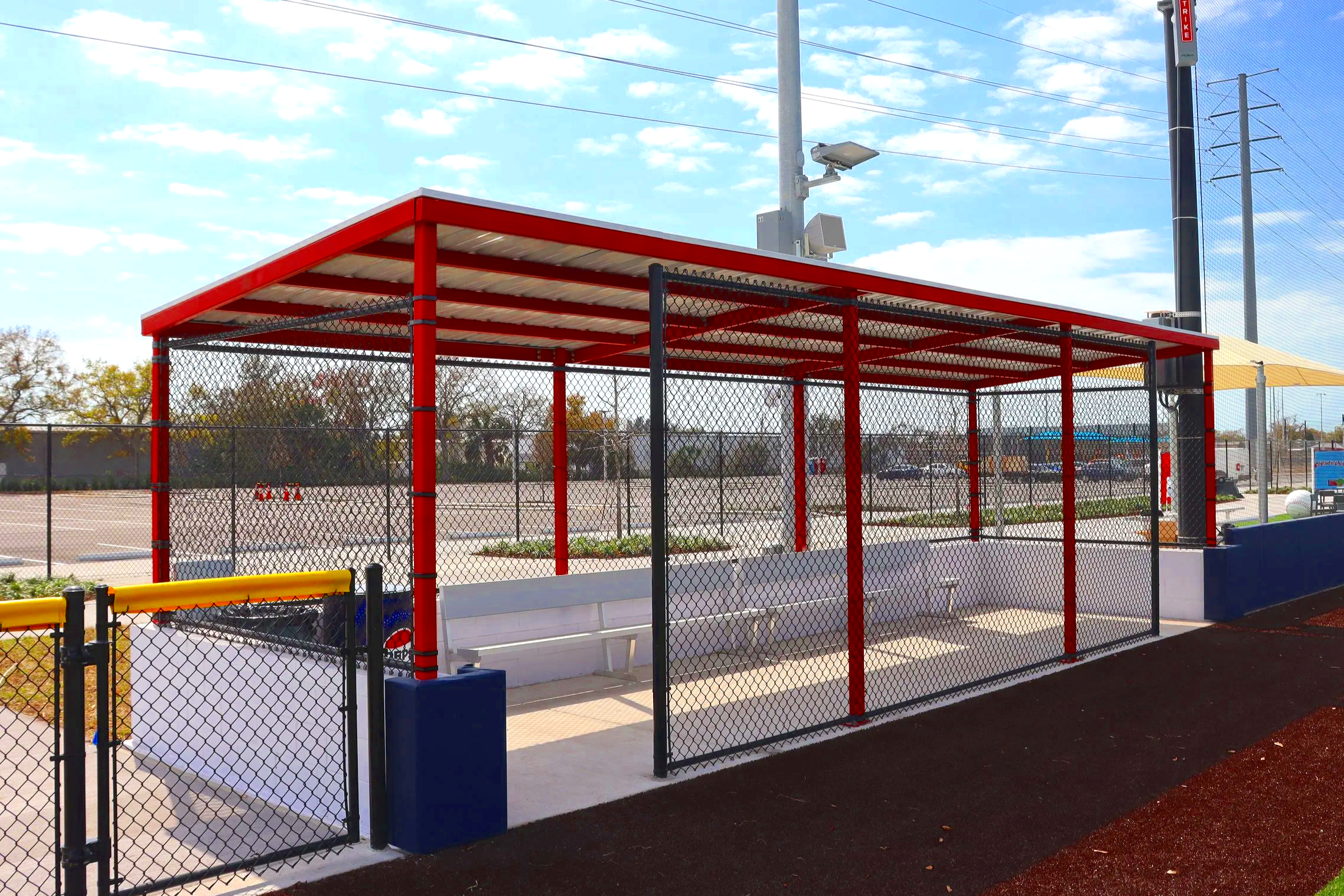 Fielder's Choice PRO dugout with red steel frame and chain link construction at baseball facility
