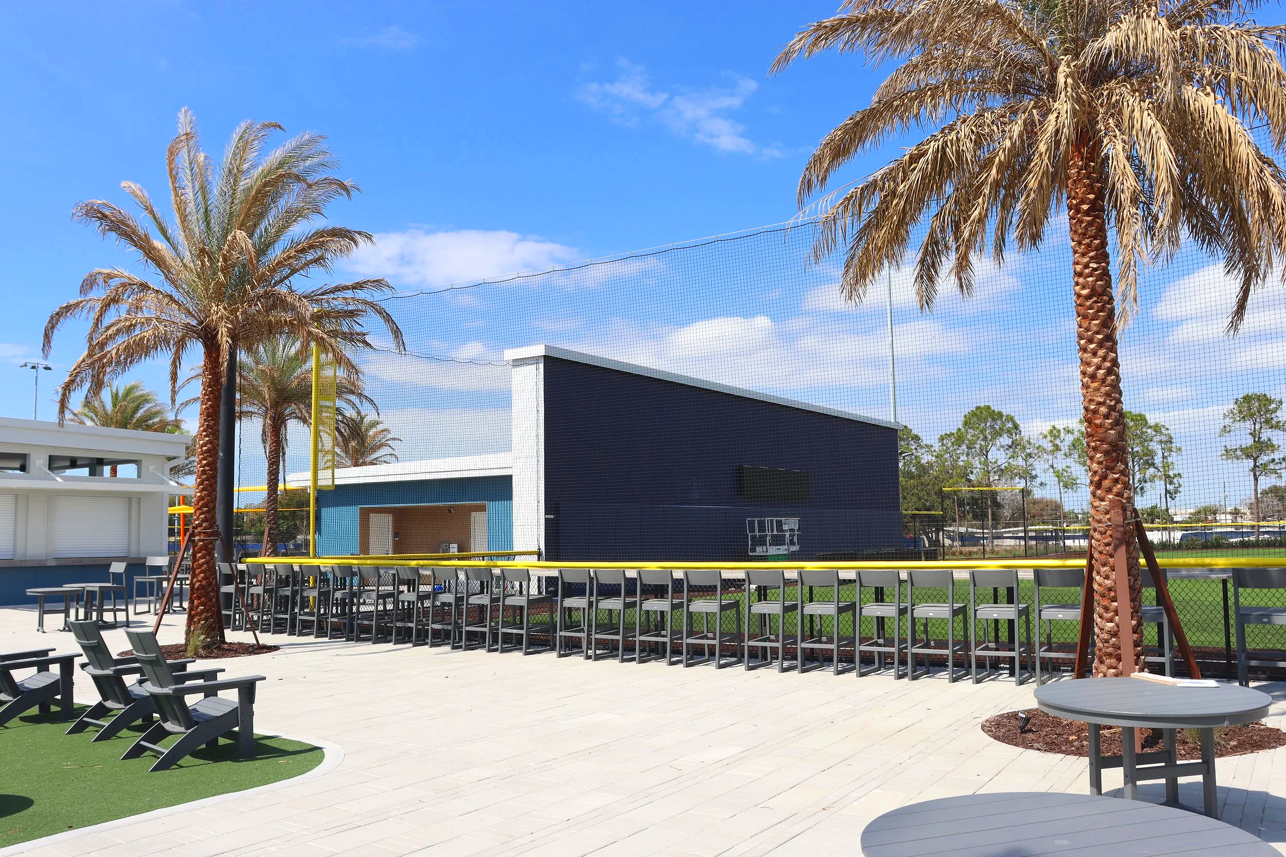 Yellow fence cap and protective netting with bleacher seating at Sprowls Horizon Sports Park in Pinellas Park Florida