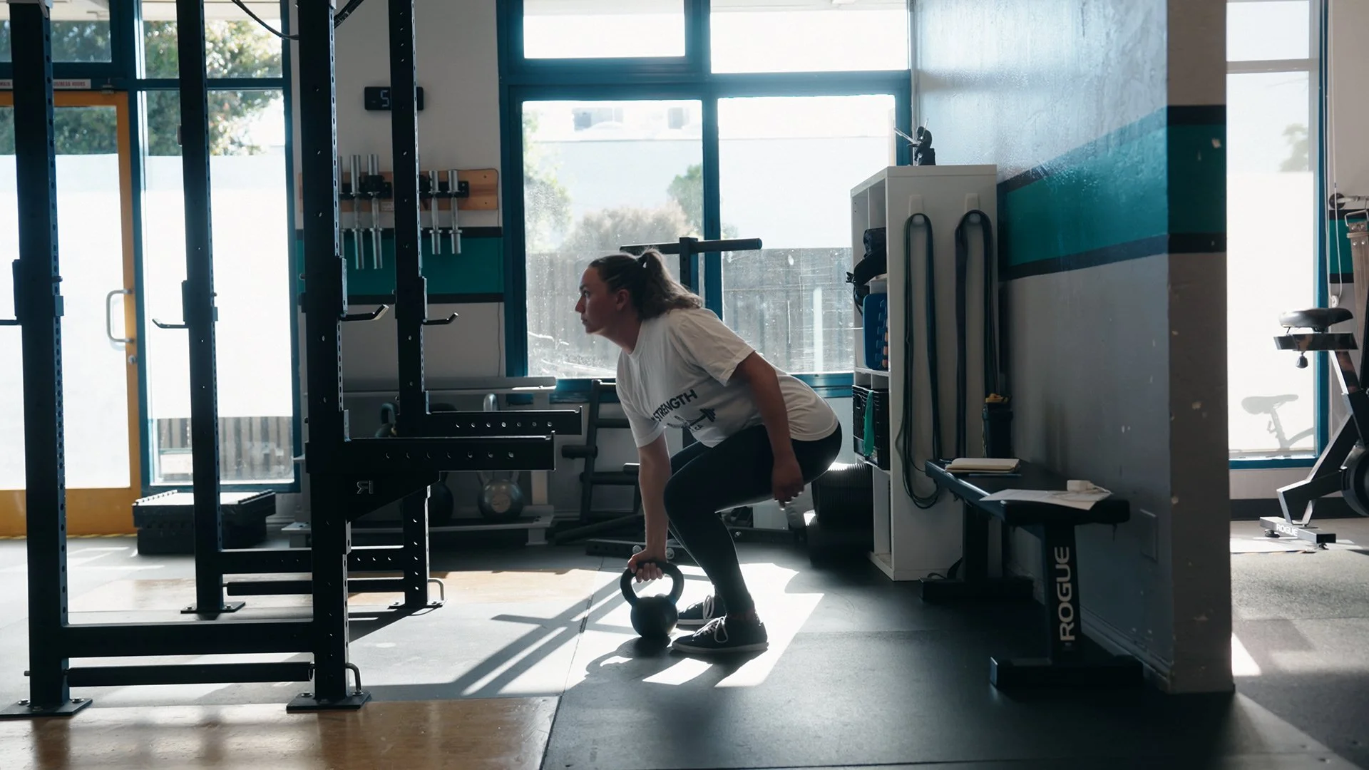Client lifting a kettle bell at Bay Strength gym in Berkeley, CA