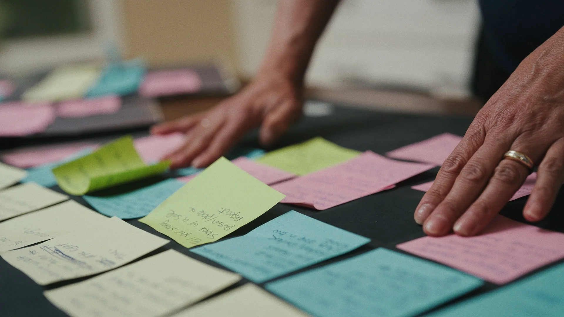 Hands touching sticky notes