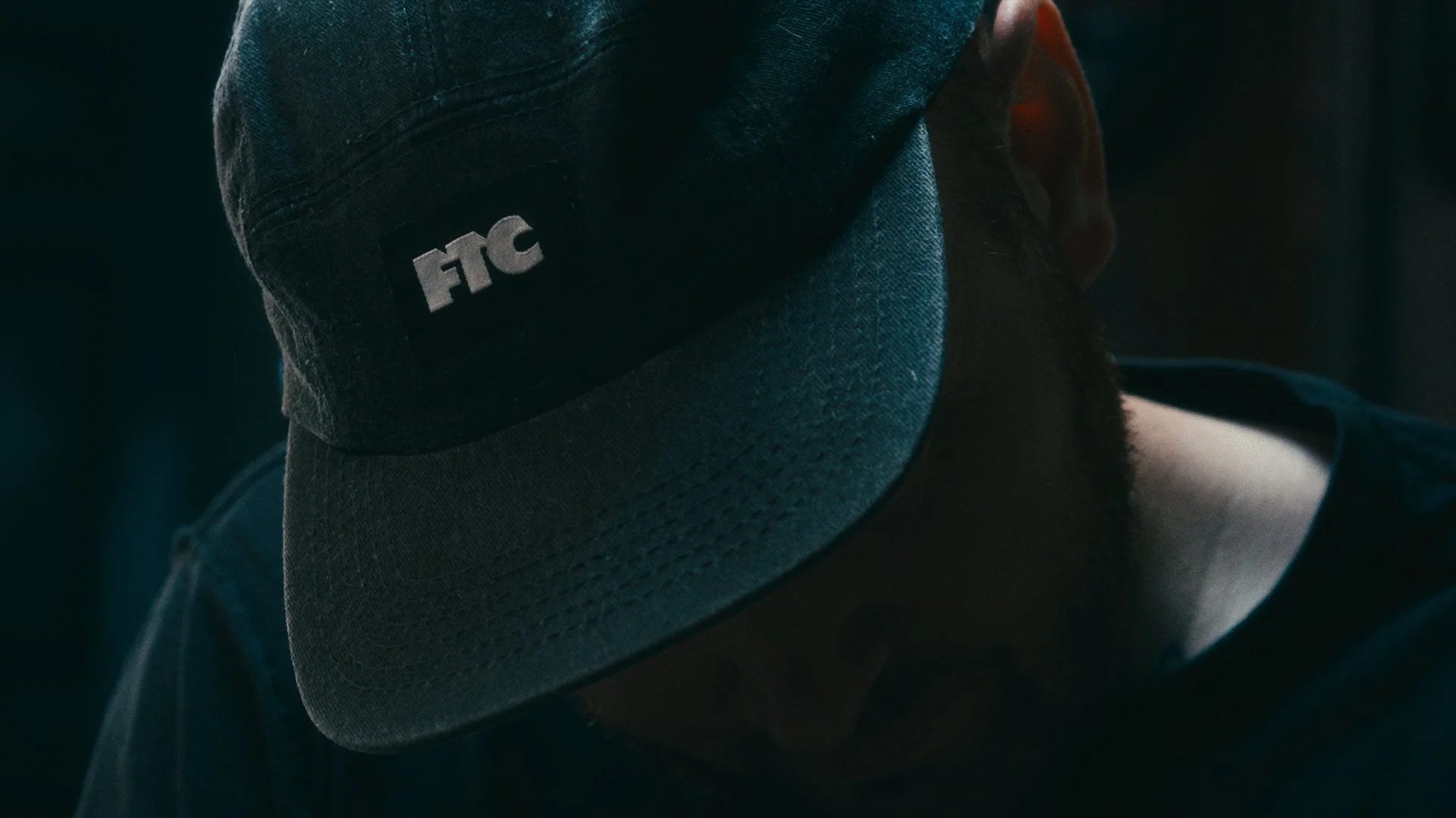 Tattoo artist wearing a black baseball cap