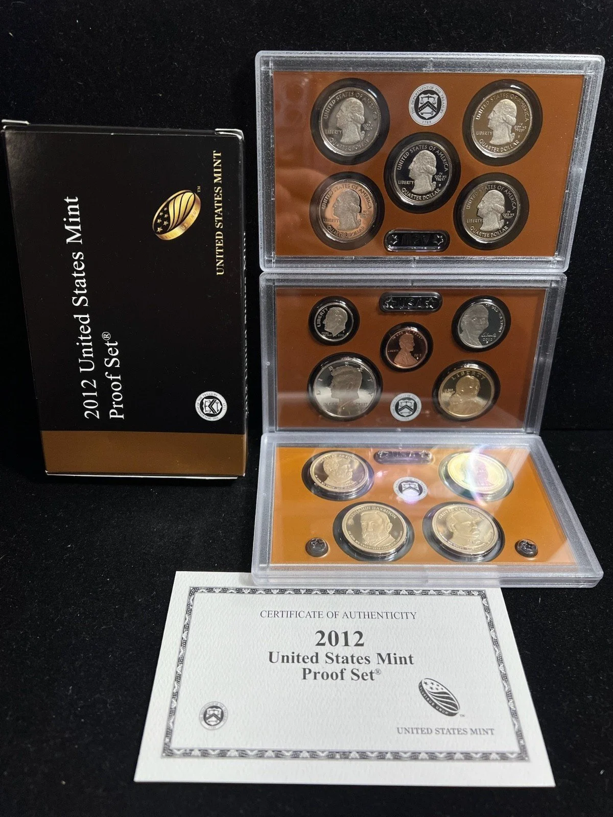 A 2012 United States Mint proof coin set including various coins in plastic cases, a Certificate of Authenticity, and packaging.