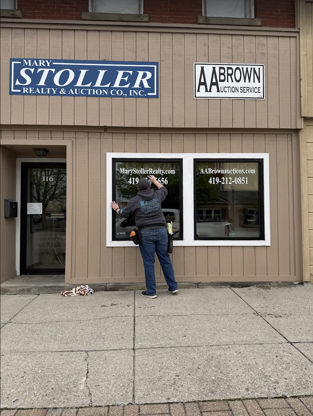 Found, Chris Perdue professionally cleaning a commercial buildings glass window.