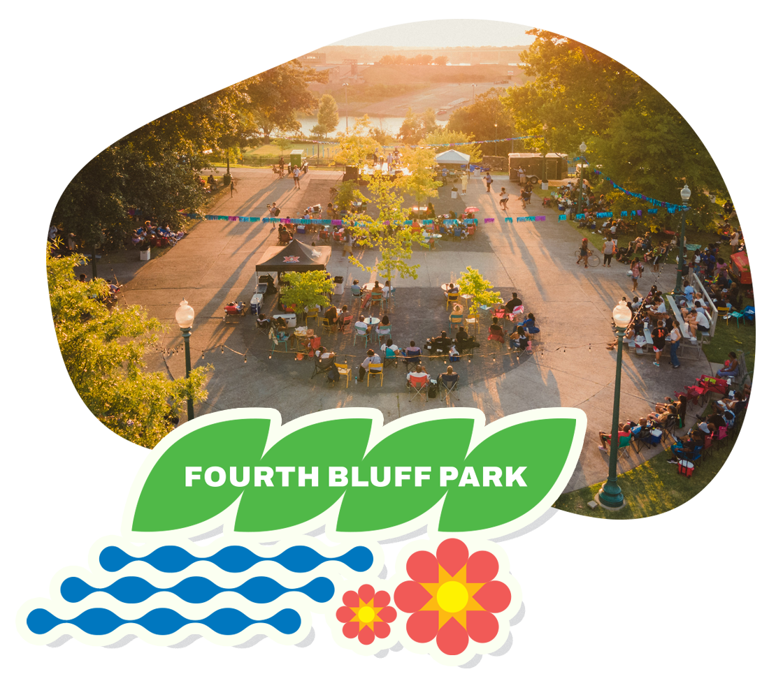 People gathered at Fourth Bluff Park for a community event during sunset, with tables, chairs, and decorations, surrounded by trees and a body of water in the background.