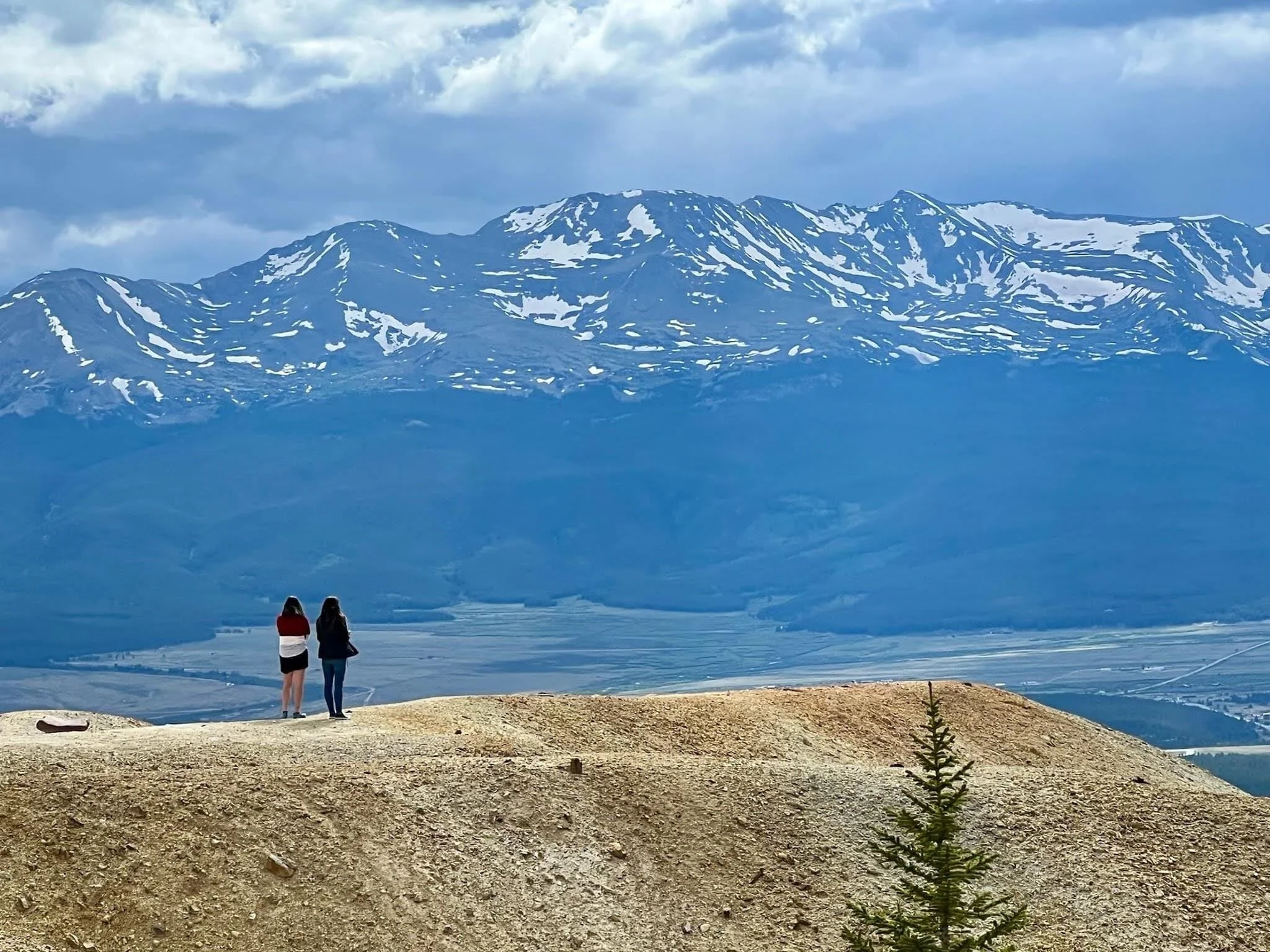 People standing side by side on ridgeline in alpine setting