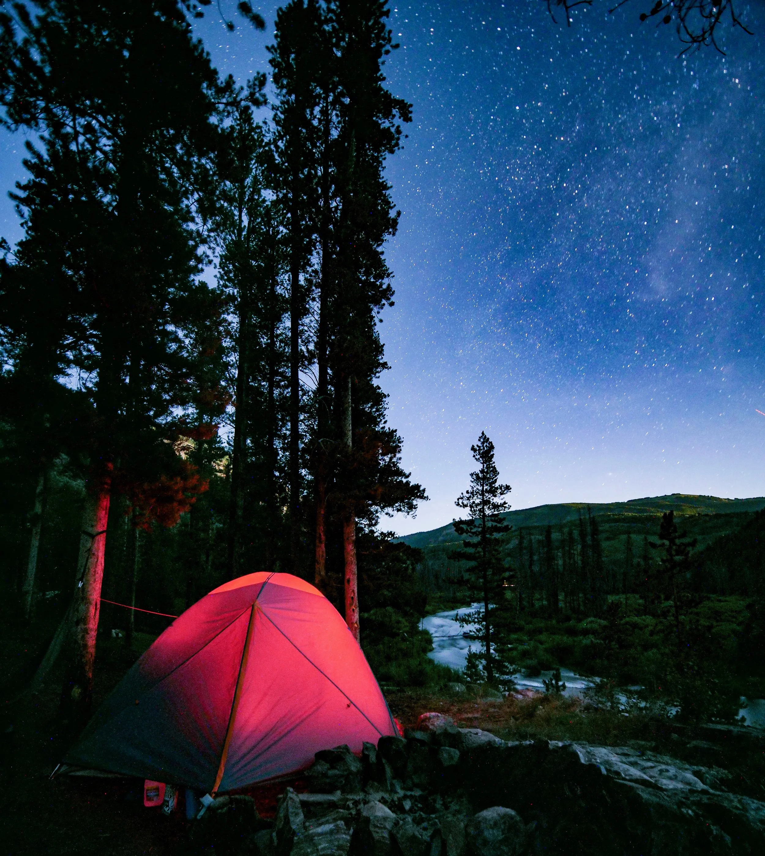 Tent glowing in the dark with starry sky background