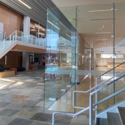Showcasing a project by DOUBLEPLAY: Modern interior of a building with glass walls, a staircase, and a lobby area.