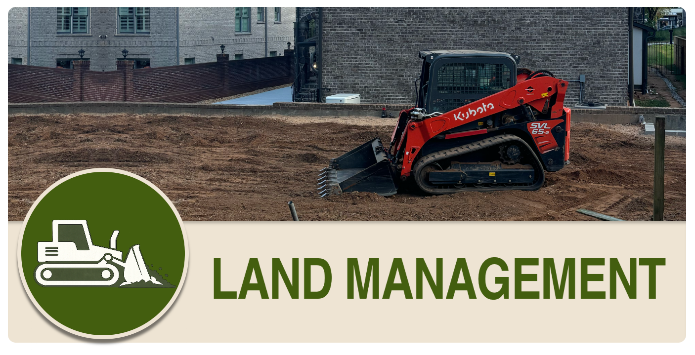 A small red Kubota compact tracked loader working on a dirt lot with a residential building in the background, labeled with a sign that says LAND MANAGEMENT.