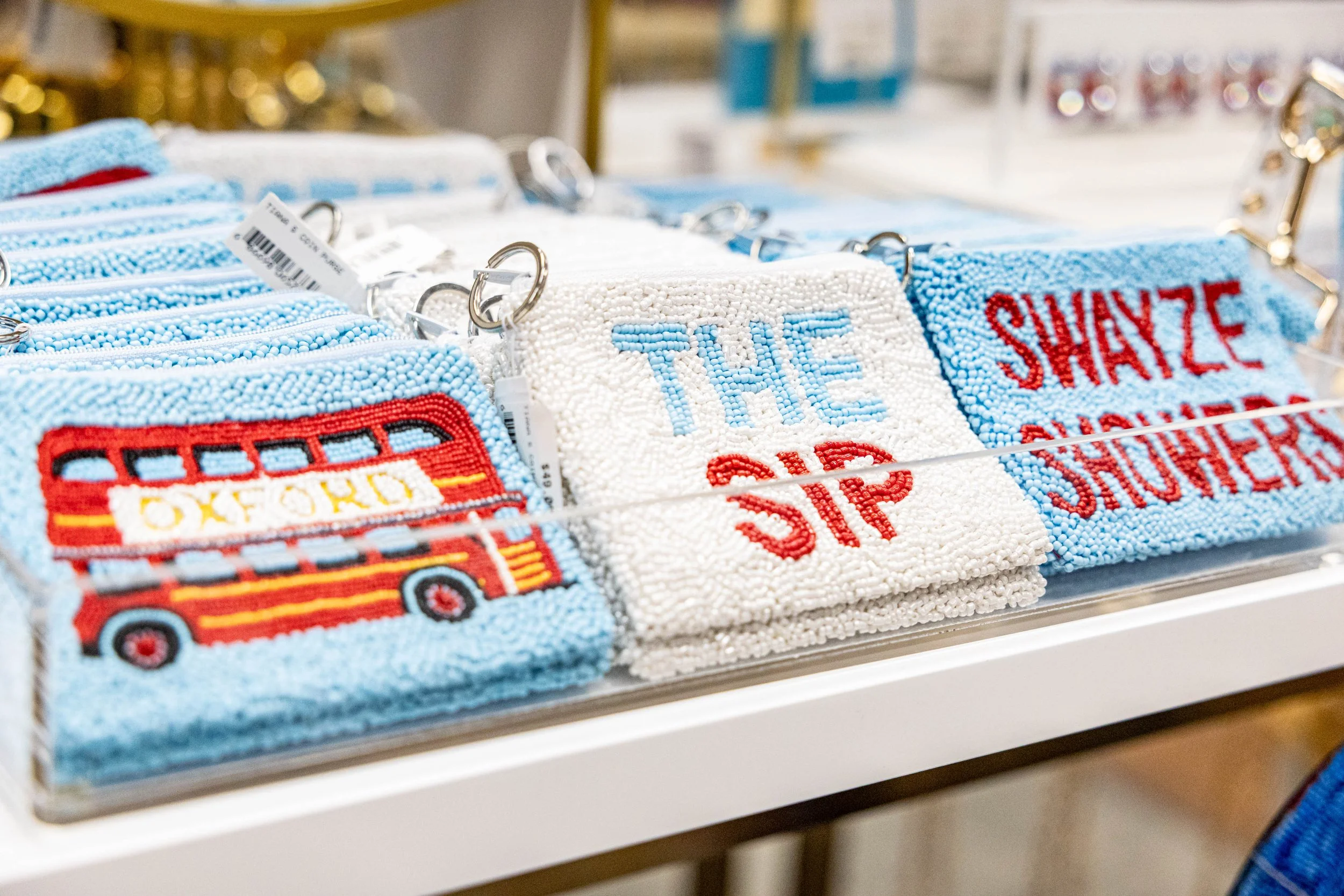 A display of beaded keychains and patches with Ole Miss themes on a store shelf.