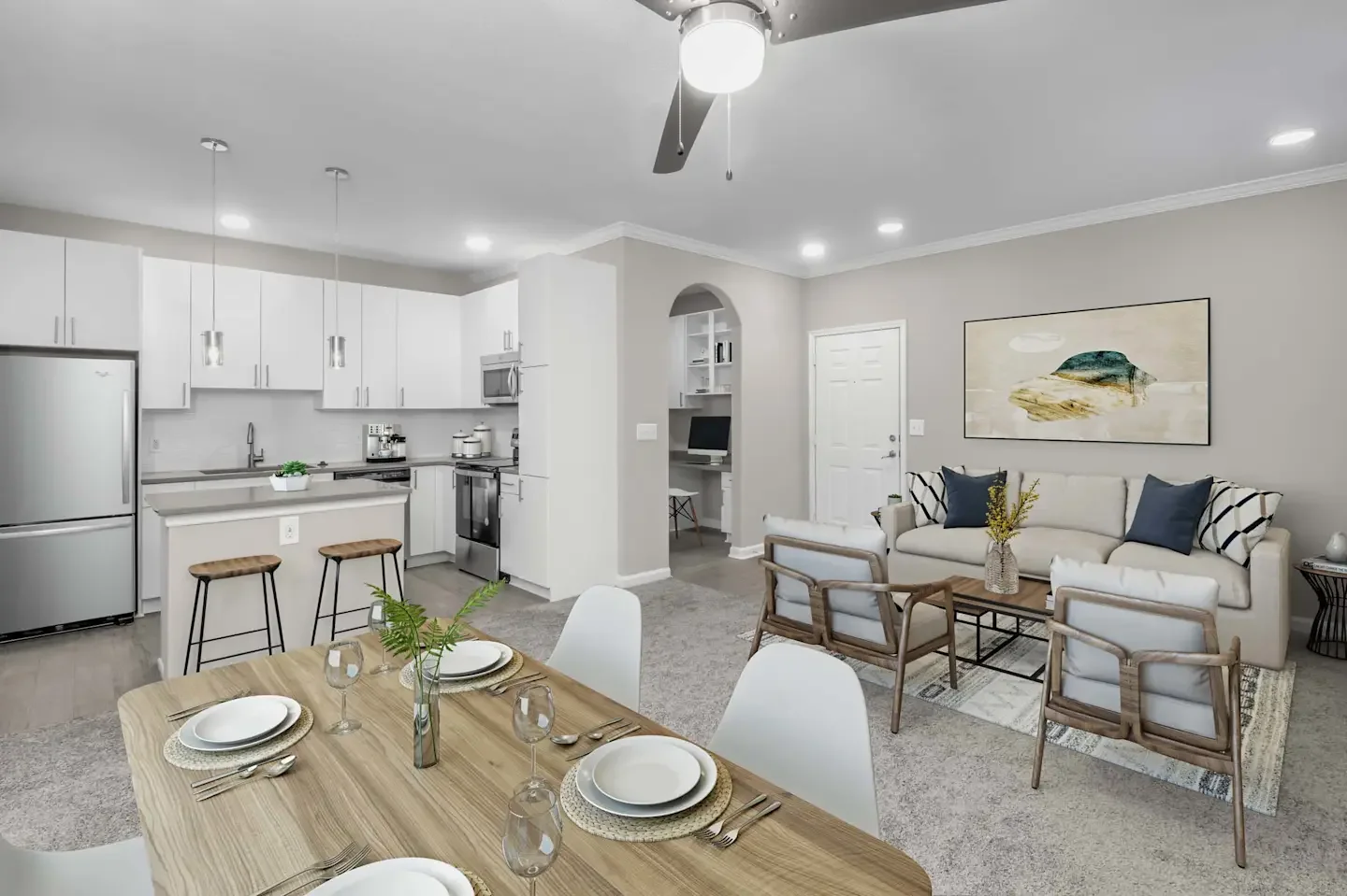 Open-plan living room and kitchen with modern decor, white kitchen cabinets, stainless steel refrigerator, dining table set for four, and a cozy seating area with a sofa and chairs, decorated with pillows and a wall art piece.