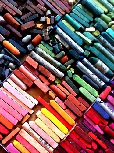 A large collection of colorful chalk pieces arranged in rows.