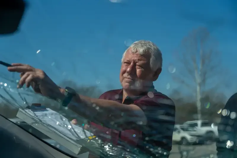 Southeastern Glass employee examining a shattered windshield.