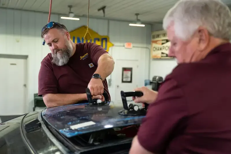 Two Southeastern Glass employees, Tim and Kevin, replacing a sunroof.
