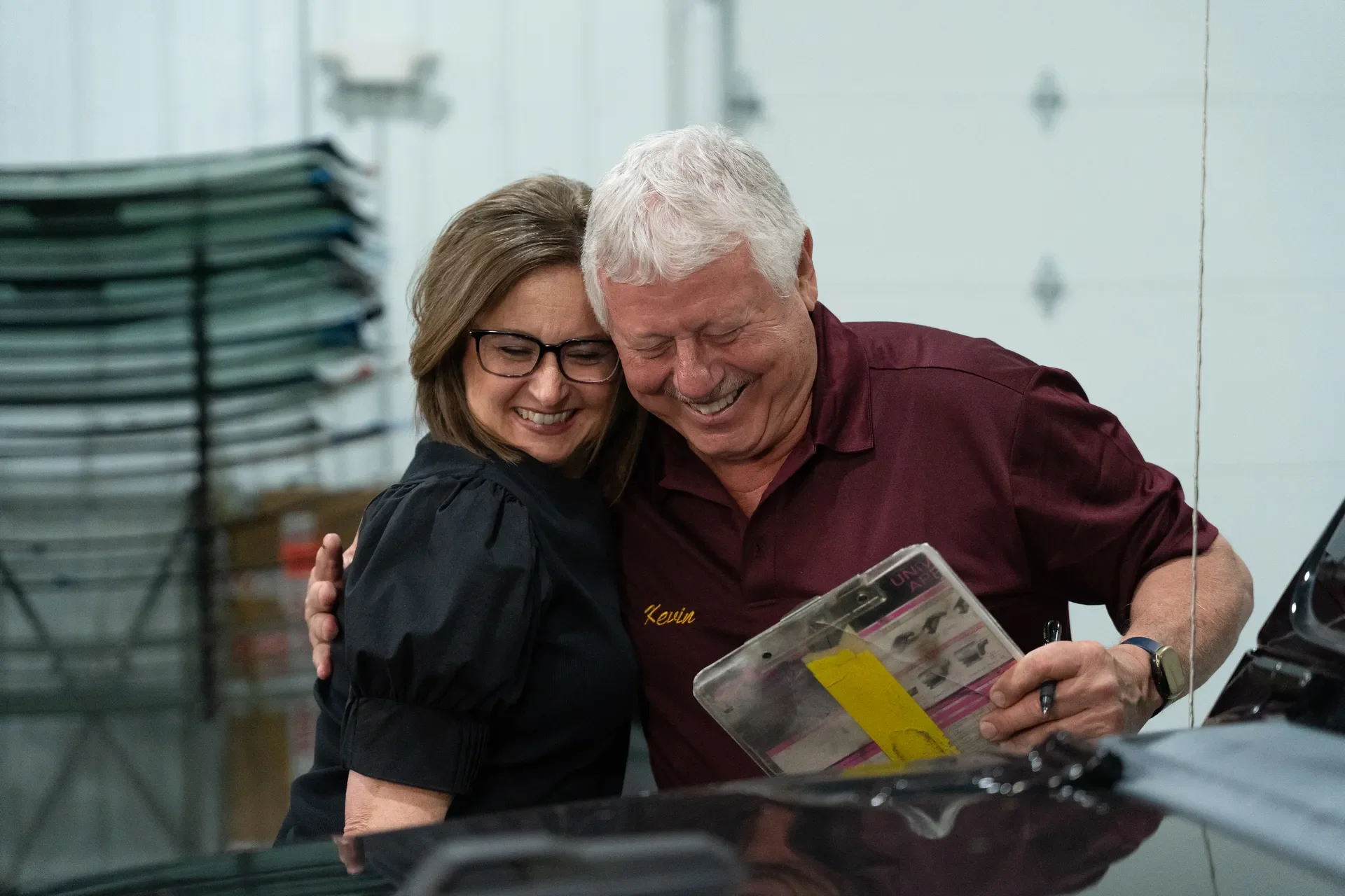 Candi and Southeastern Glass owner are smiling and hugging each other.