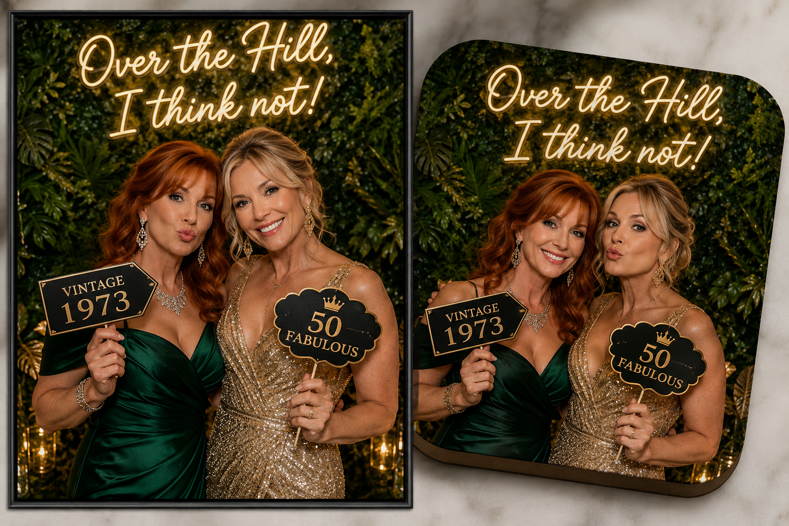 Two women at a 50th birthday celebration, holding signs that read "Vintage 1973" and "50 Fabulous". They are dressed in elegant attire, with a green and gold dress, against a green leafy background with neon lights that say "Over the Hill, I think not!".