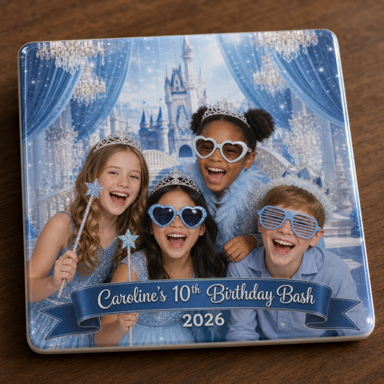 A photo of four children at a birthday party with a fairy tale castle background, all wearing princess and fairy accessories, smiles, and glasses, holding star-shaped wands. The text on the photo reads: "Caroline's 10th Birthday Bash 2026."